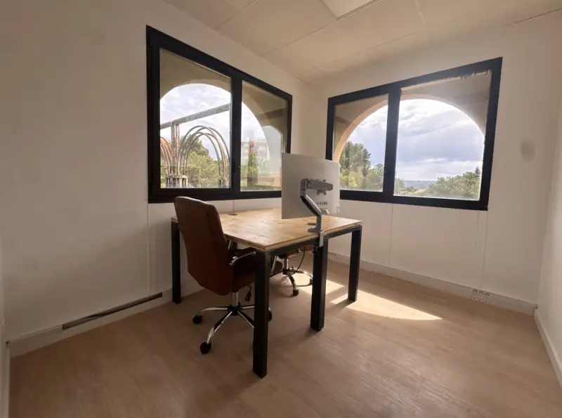 Bureau fermé avec deux fenêtres en arcade et lumière au sol