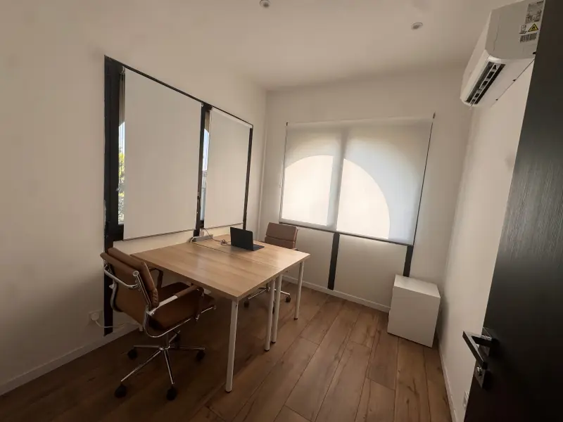 Bureau privé de deux postes à l’étage du bâtiment E2, grande fenêtre en arcade
