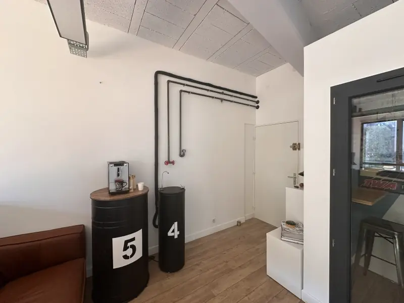 Coin café avec machine à café et fontaine d’eau fraîche, canapé en cuir